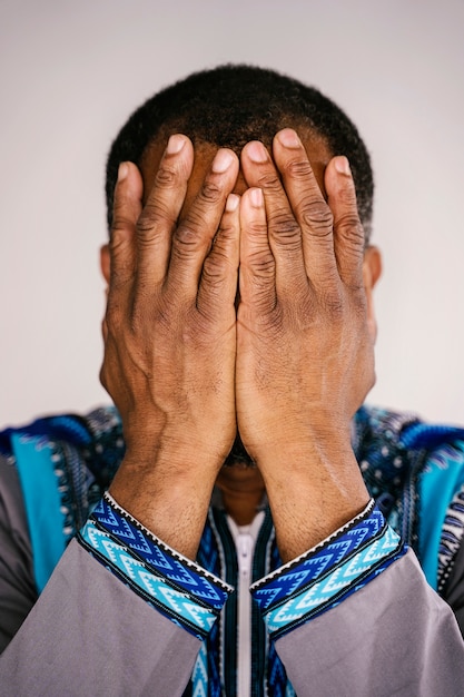 Portret etniczny mężczyzna próbuje kontrolować swoją frustrację, starając się nie płakać. Udręka emocji.
