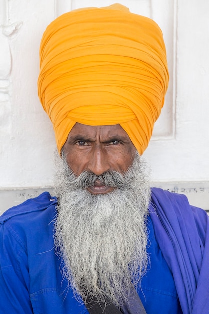 Portret Indyjskiego Mężczyzny Sikh W Pomarańczowym Turbanie Z Krzaczastą Brodą. Amritsar, Indie. ścieśniać