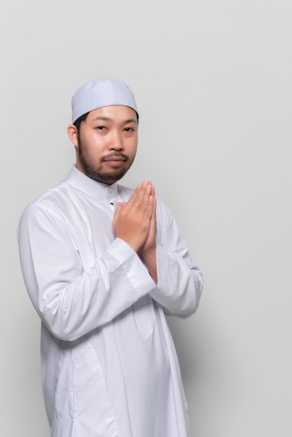 Portret inteligentnego przystojnego muzułmańskiego mężczyzny na białym tlePozdrowienie w odniesieniu do stylu tajskiego