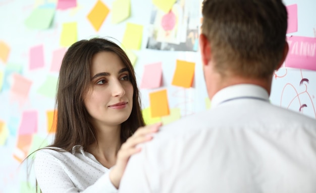 Portret inteligentnej bizneswoman stojącej w nowoczesnym miejscu pracy z biznesmenem i rozmawiającej o nowym projekcie Koncepcja kreatywnego projektowania artystycznego Niewyraźne tło