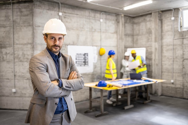 Portret inżyniera budownictwa lub kierownika projektu i zespołu architektów na budowie