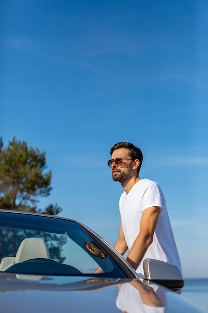 Portret kaukaski facet stojący w samochodzie na zewnątrz w ciągu dnia