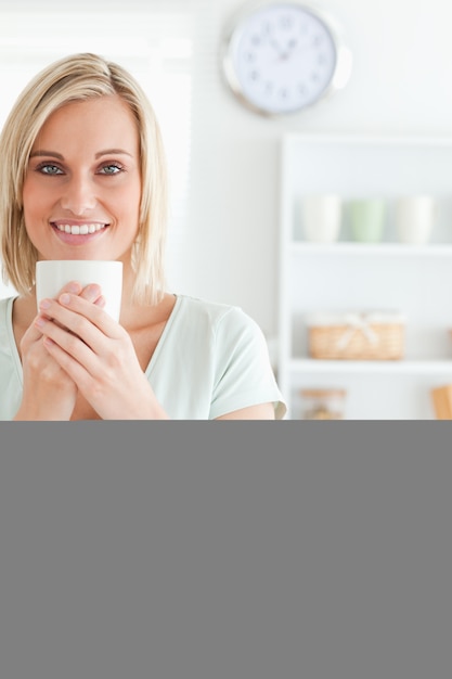 Portret kobieta bierze w odorze kawowy patrzeć w kamerę