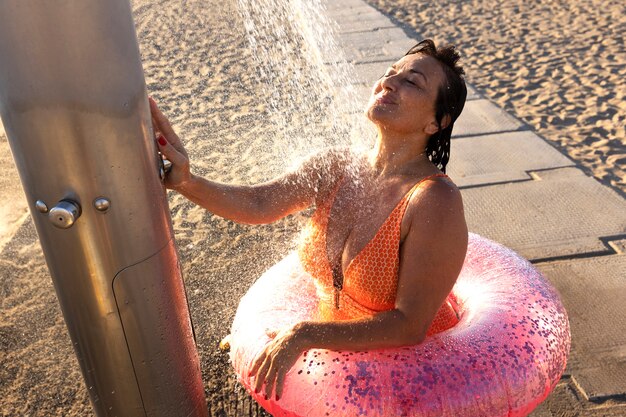 Zdjęcie portret kobiety biorącej prysznic na plaży