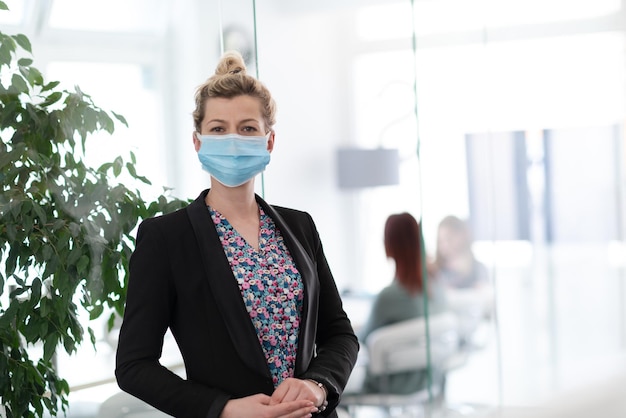 portret kobiety biznesu noszący maskę medyczną w jasnym nowoczesnym biurze nowa normalna koncepcja epidemii koronawirusa prawdziwi ludzie