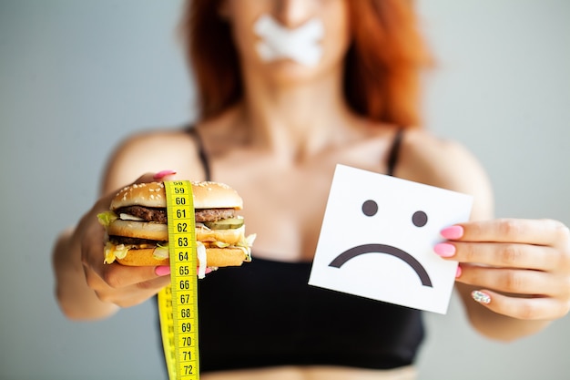 Zdjęcie portret kobiety chce zjeść burgera, ale usta skochem utknął