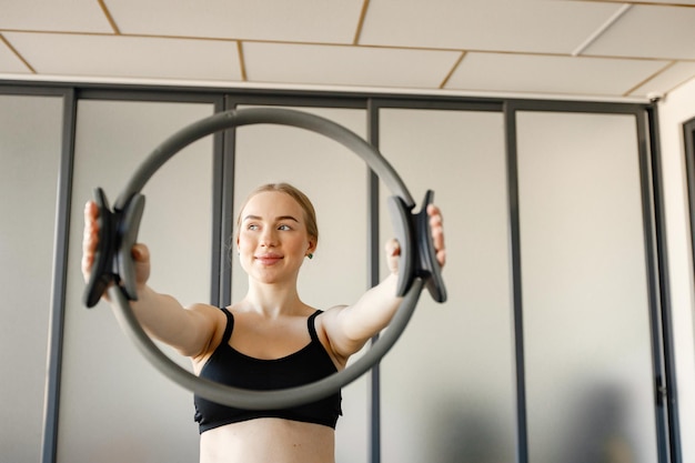 Portret Kobiety ćwiczącej Na Specjalnym Sprzęcie Wysportowana Kobieta ćwicząca Na Siłowni Kobieta Ubrana W Czarny Sportowy Top