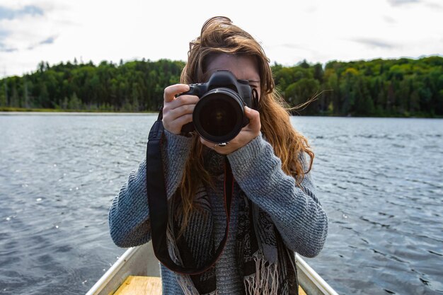 Zdjęcie portret kobiety fotografującej nad jeziorem