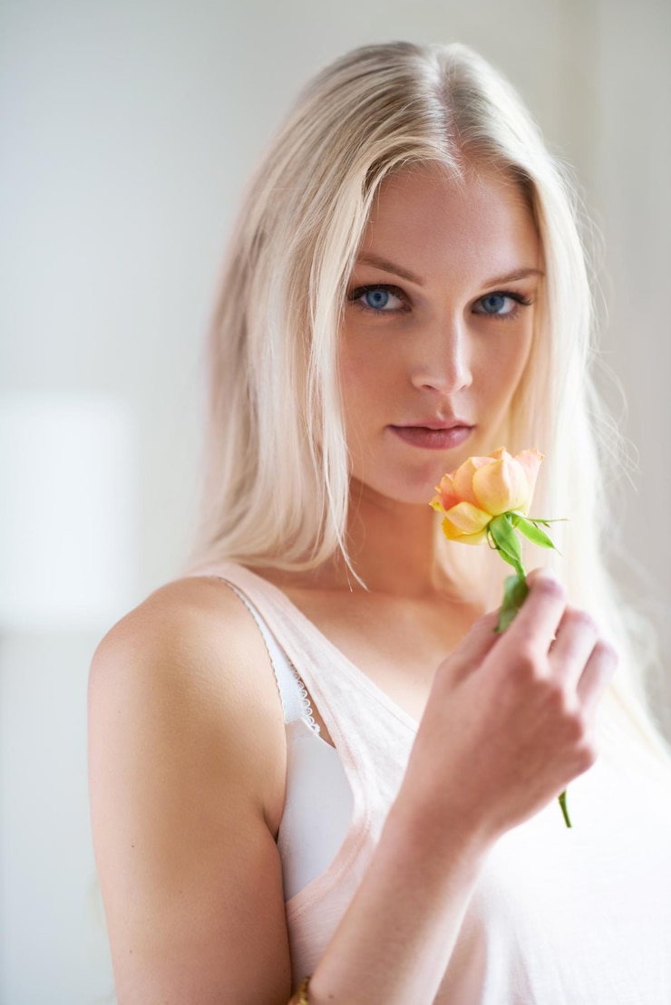 Zdjęcie portret kobiety i trzymania kwiatu w sypialni dla romansu z headshot w norwegii osoba kobieca patrząca i ręka z różą dla miłości zaufania lub opieki w związku dla wzrostu więzi i partnera