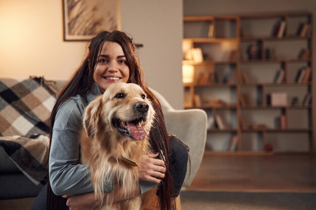 Portret kobiety, która jest z psem golden retriever w domu