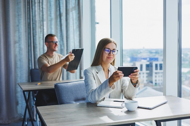 Portret kobiety menedżera w stroju formalnym wykonującego pracę biurową i rozmawiającego przez telefon udanej europejskiej szefowej w okularach optycznych do korekcji wzroku pozującej przy biurku