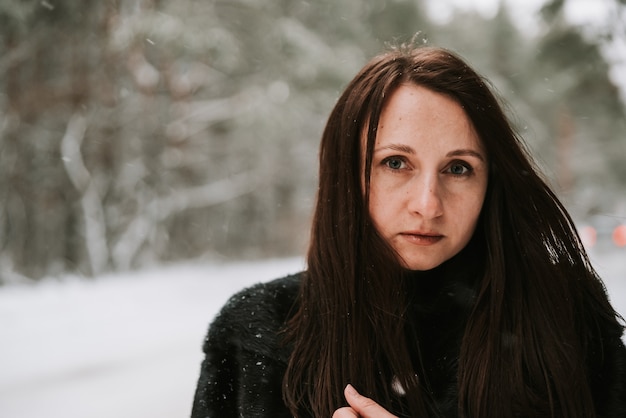 Portret kobiety na tle zaśnieżonego lasu