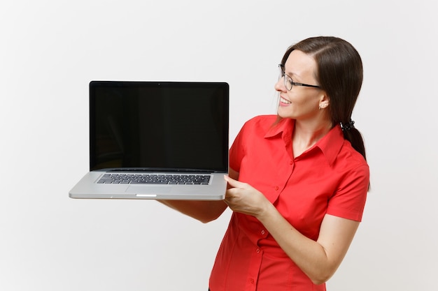 Portret kobiety nauczyciel biznesu w czerwonej koszuli przytrzymaj komputer pc laptop z pustym czarnym pustym ekranie, aby skopiować miejsce na białym tle. Nauczanie edukacji w koncepcji uniwersytetu liceum.