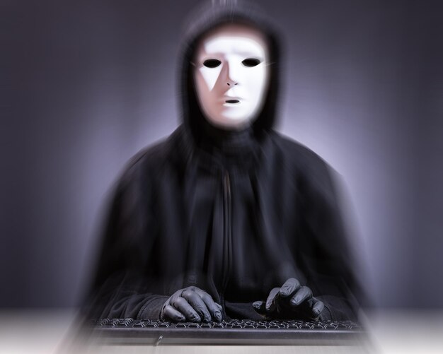 Portret kobiety noszącej maskę podczas pisania na klawiaturze na niewyraźnym tle