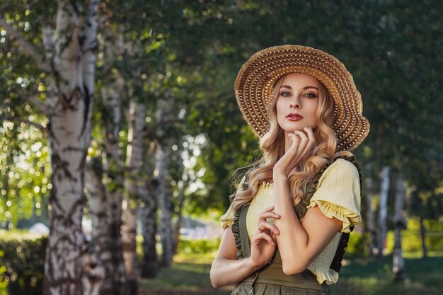 Portret kobiety o blond włosach w ubraniach retro w parku lub ogrodzie