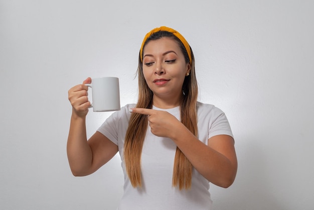 Portret kobiety pokazujący białą filiżankę Osoba trzymająca filiżankę kawy w białym tle