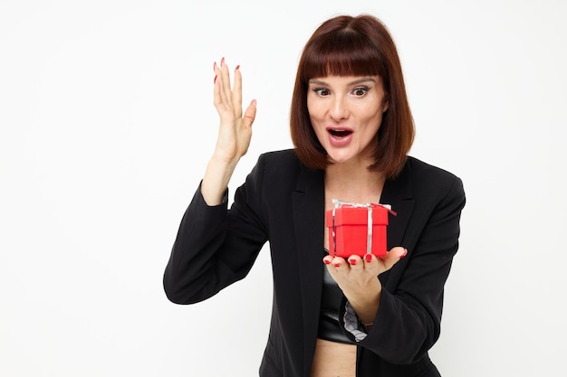 Portret kobiety pozującej z czerwonym pudełkiem na prezent niespodzianka na białym tle