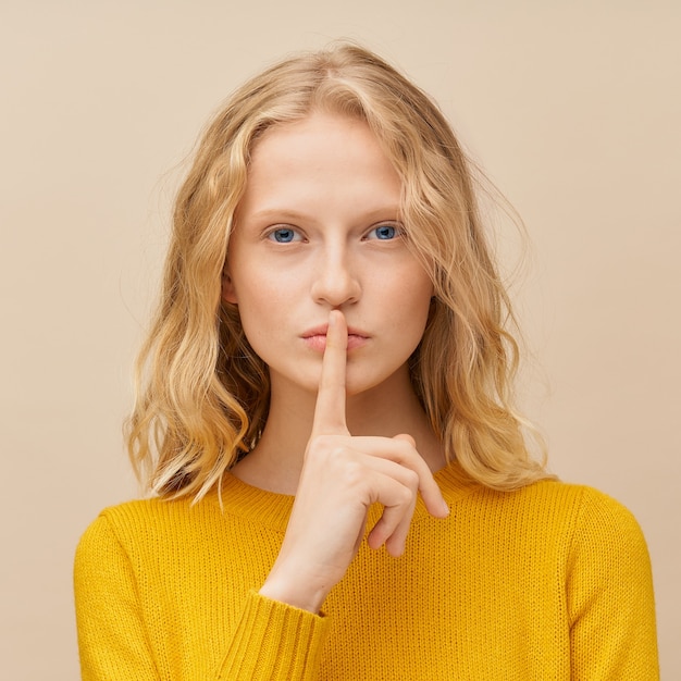 Portret kobiety przykładającej palec do ust, proszę nie hałasować, milczeć, milczeć