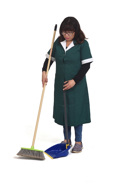 Portret kobiety sprzątającej, która zamiata na białym tle.