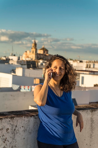 Portret kobiety stojącej na telefonie komórkowym na tle krajobrazu miejskiego