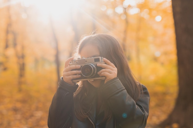 Zdjęcie portret kobiety trzymającej kamerę jesienią