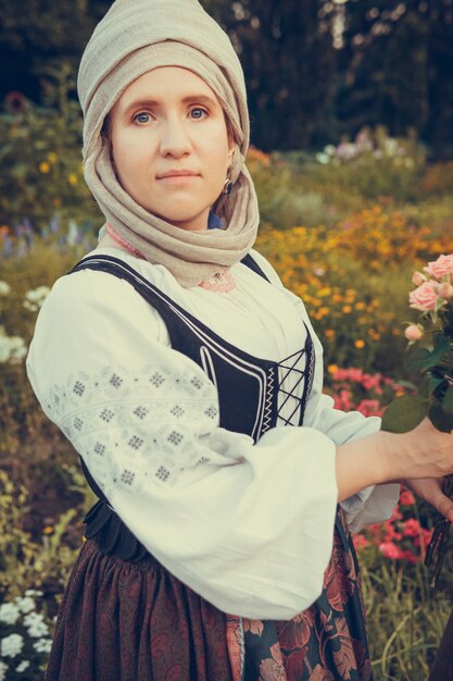 Portret kobiety ubranej w historyczne stroje barokowe z chustką na głowie, na zewnątrz. Średniowieczny strój klasy średniej