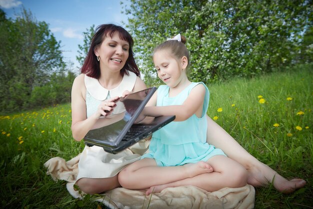 Zdjęcie portret kobiety używającej laptopa siedzącej na boisku