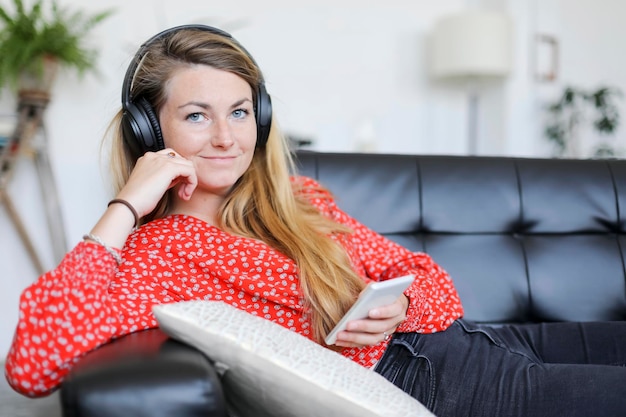 Portret kobiety używającej telefonu komórkowego w domu