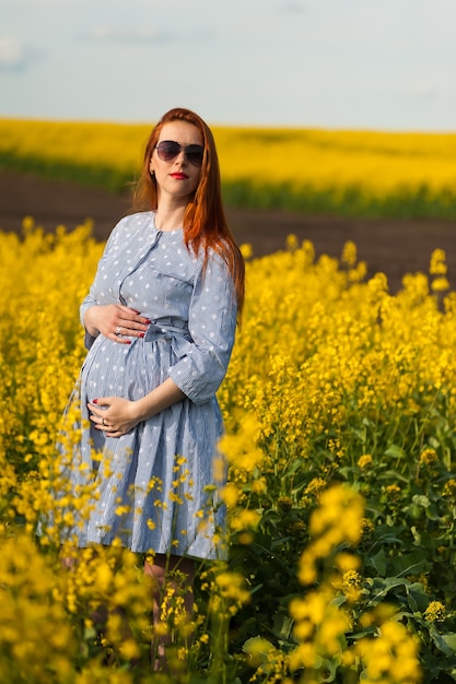 Portret kobiety w ciąży na żółtym polu