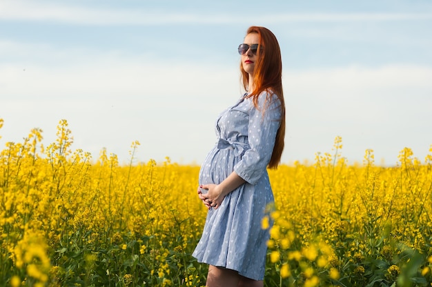 Portret kobiety w ciąży na żółtym polu