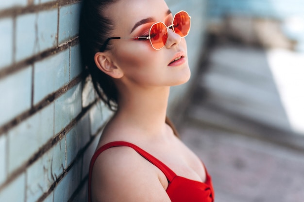 Portret kobiety w czerwonych okularach przeciwsłonecznych na zewnątrz