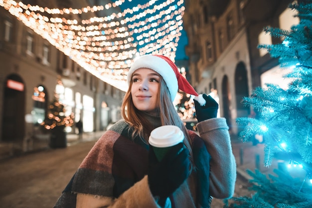 portret kobiety w kapeluszu Santa gospodarstwa filiżankę kawy