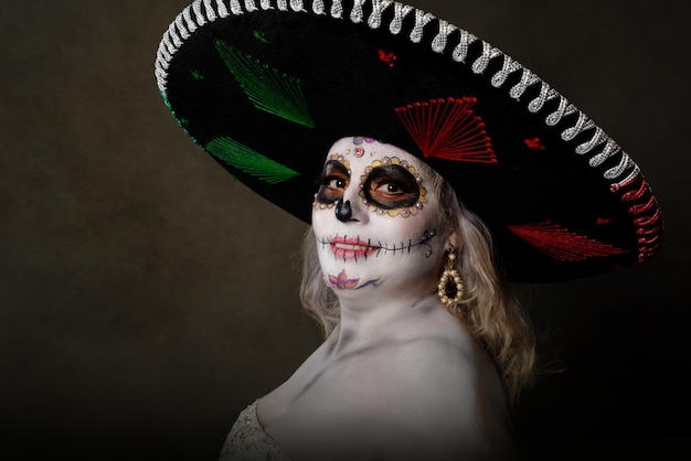 Portret kobiety w makijażu Catrina, w sukni ślubnej i kapeluszu charro