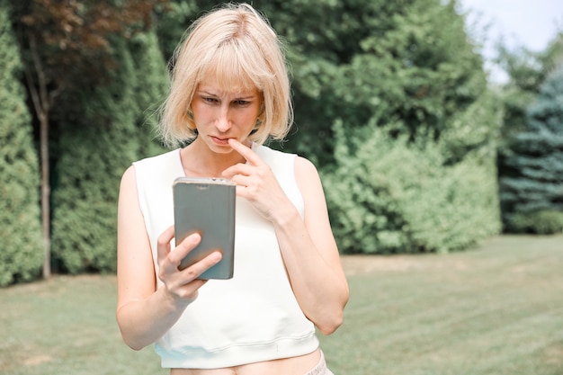 Portret kobiety w naturze ze smartfonem