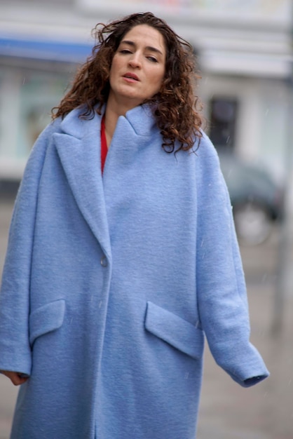 Zdjęcie portret kobiety w płaszczu stojącej na drodze w zimie