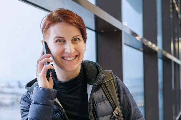 Portret kobiety w średnim wieku rozmawiającej przez telefon komórkowy