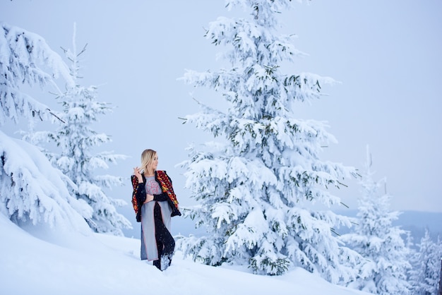 Portret kobiety w zimowy dzień na tle śnieżnego krajobrazu