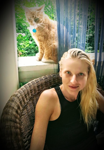 Zdjęcie portret kobiety z kotem na parapecie w domu