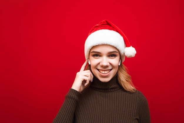 Portret Kobiety Z Santa Hat Słuchania Muzyki W Słuchawkach Bezprzewodowych