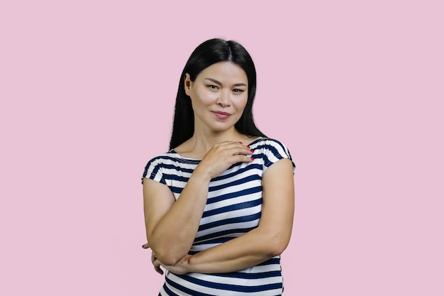 Portret koreańskiej azjatyckiej kobiety w pasiastej koszulce odizolowanej na różowym tle