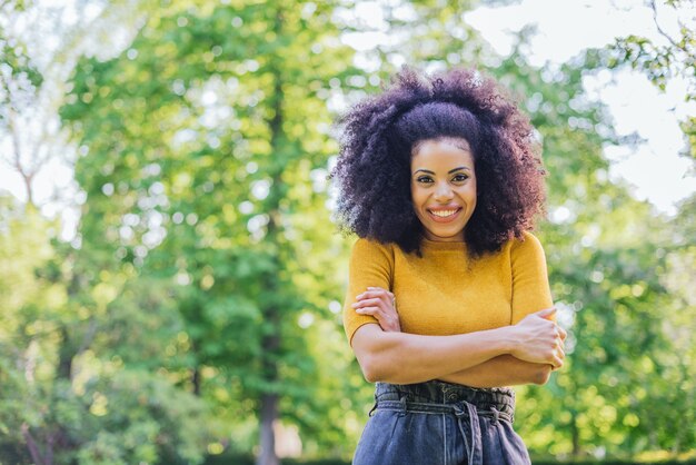 Portret ładnej dziewczyny afro w ogrodzie. W połowie strzału. Selektywne skupienie.