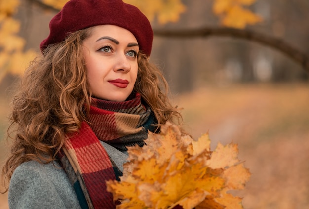 Portret ładnej dziewczyny na tle żółtych liści