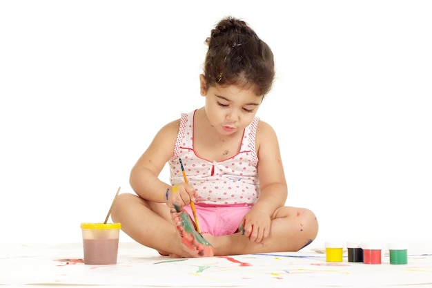 Portret ładnej młodej dziewczyny malującej obraz na białym tle