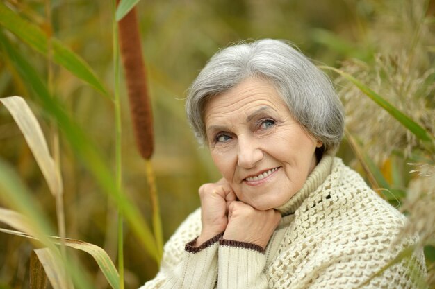 Portret ładnej starszej kobiety w jesiennym parku