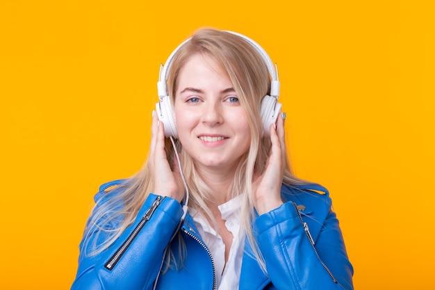 Portret ładny pozytywny młoda blondynka słuchanie ulubionej muzyki w słuchawkach w kolorze niebieskim