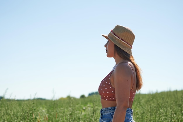 Portret latynoskiej kobiety w kowbojskim kapeluszu na wsi w słoneczny dzień