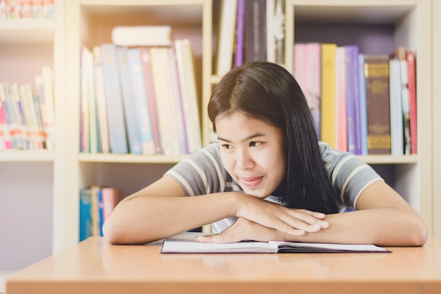 Portret mądry Azjatycki studencki czytanie i robić badaniu w szkoły wyższa bibliotece