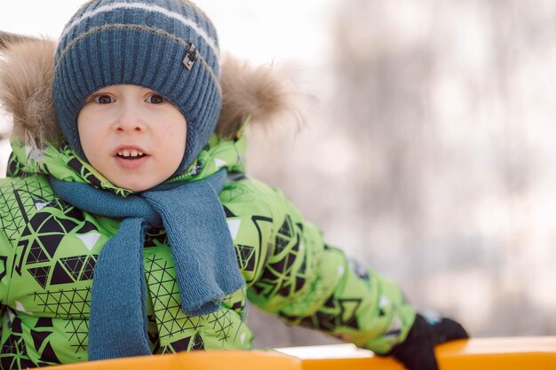 Portret małego chłopca idącego na placu zabaw w mroźny zimowy dzień