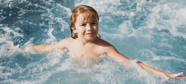 Portret małego chłopca pływającego w morzu dziecko śmiejące się w wodzie fal na morzu śmieszna twarz dzieciaków