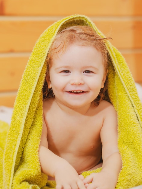 Portret małego chłopca pokrywa ciało pod ręcznikiem po koncepcji kąpieli dzieci twarz zbliżenie głowy shoo